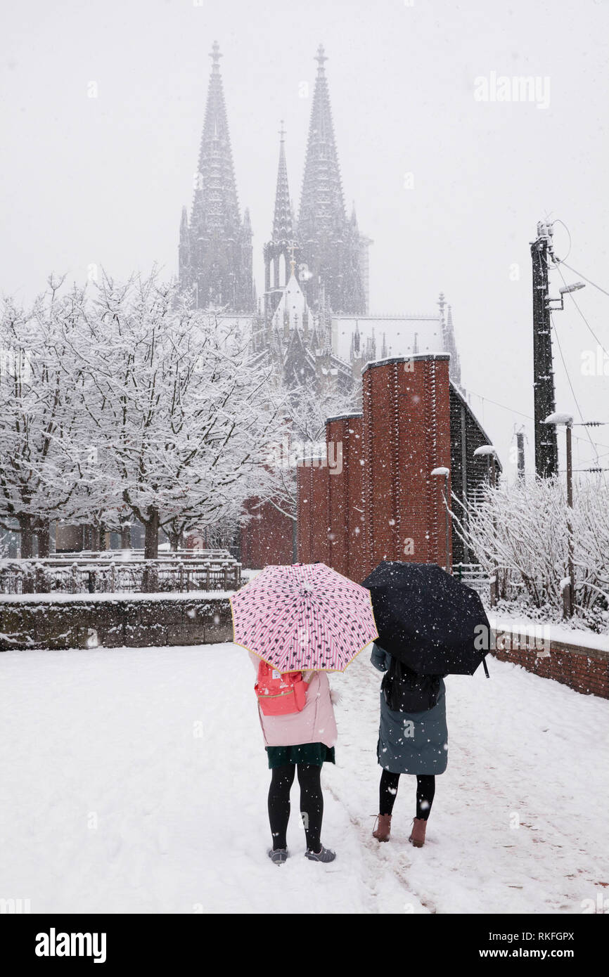 two women with umbrellas during snwofall near the cathedral, snow, winter, Cologne, Germany.  zwei Frauen mit Schirmen bei Schneefall nahe Dom, Schnee Stock Photo