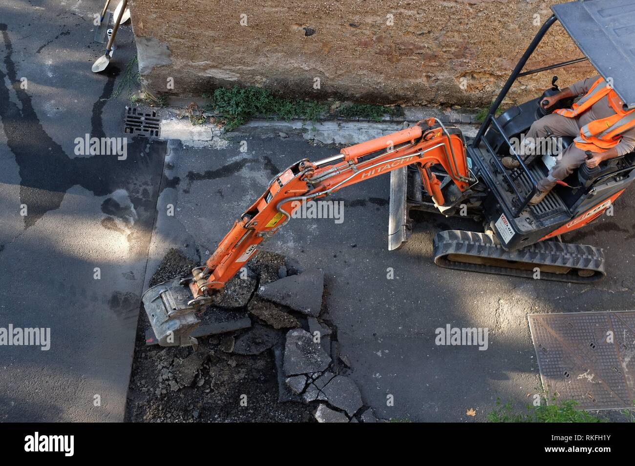 Road workers tear up old asphalt on a small street preparing to repave it. Pezenas, France Stock Photo