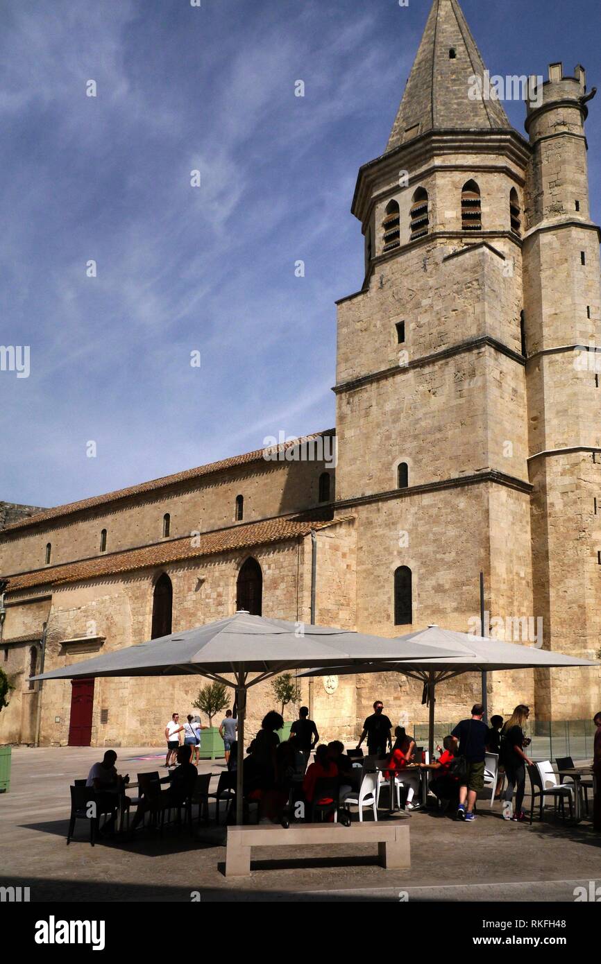 Diners eat outdoors in the Place Madeleine, Beziers, France in front of the 12th century Church Saint Madeleine. Stock Photo