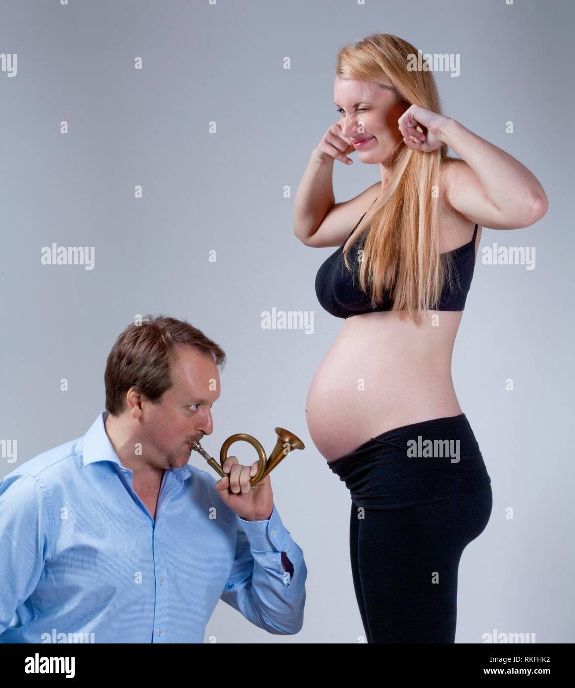 Pregnant Woman with her Partner Playing Music for the Baby. Stock Photo