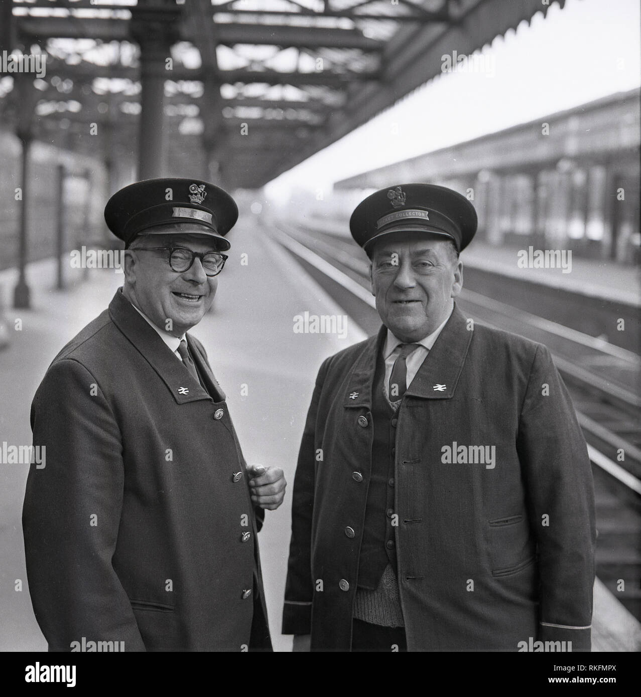 1968, picture shows two cheerful uniformed British Rail staff, a station foreman and ticket collector standing together on the platform at Blackheath railway station, Blackheath, London, England, UK. Stock Photo