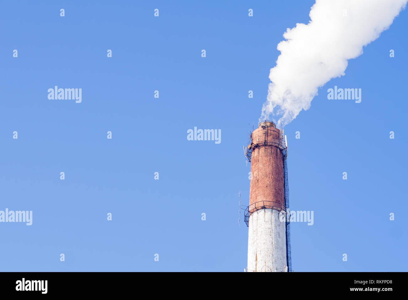 Smoke from industrial chimneys against the blue sky. Pollution. Stock Photo