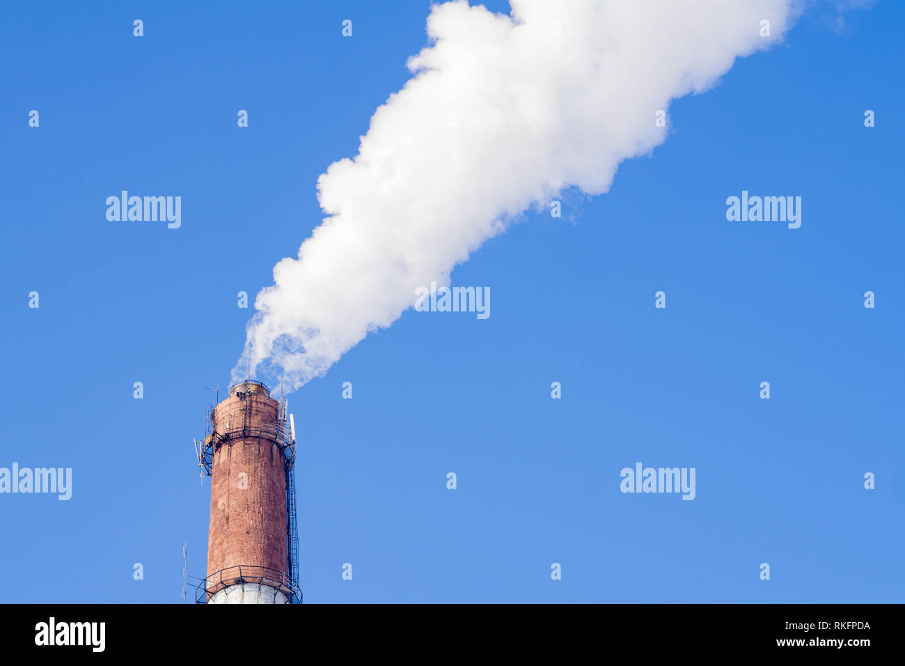 Smoke from industrial chimneys against the blue sky. Pollution. Stock Photo