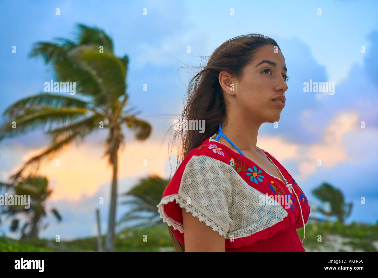 Mexican girl embrodery dress at sunset in Caribbean palm trees. Stock Photo