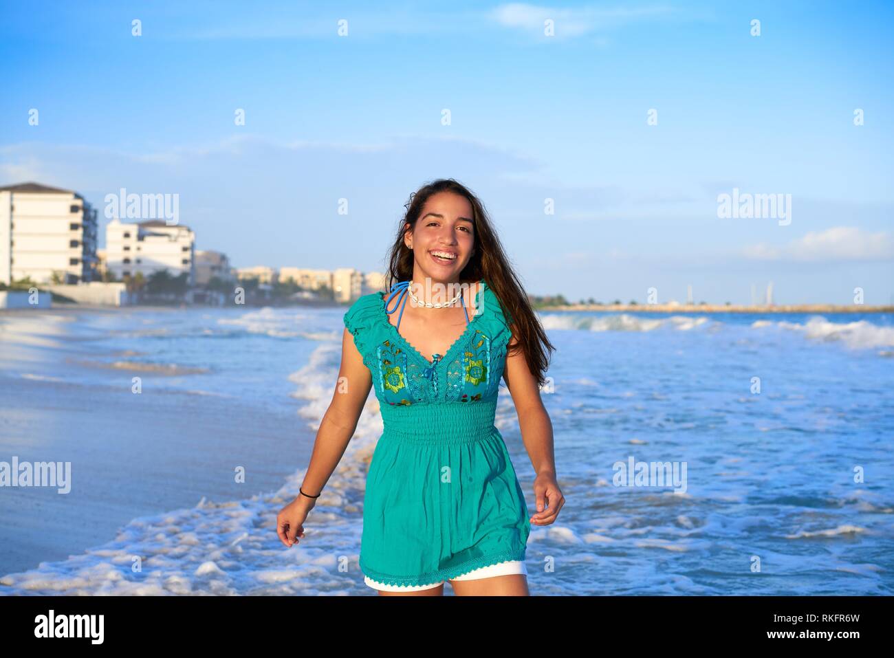 Latin beautiful girl in Caribbean beach sunset with embroidery dress. Stock Photo