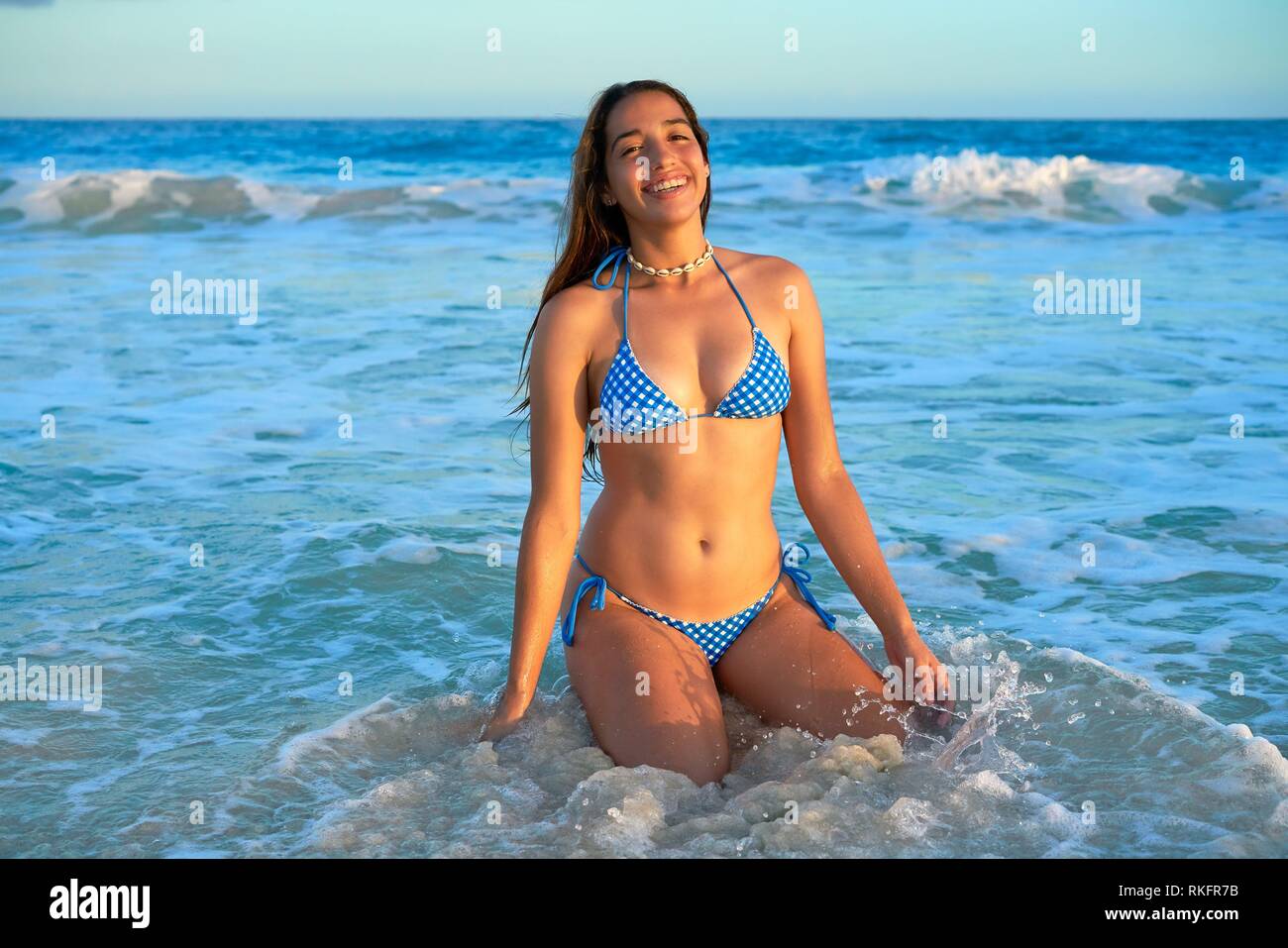 Latin beautiful bikini girl happy sitting in Caribbean beach sunset Stock  Photo - Alamy