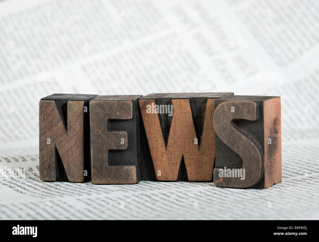 News, word written with vintage wooden letterpress printing blocks on newspaper, shallow depth of field Stock Photo