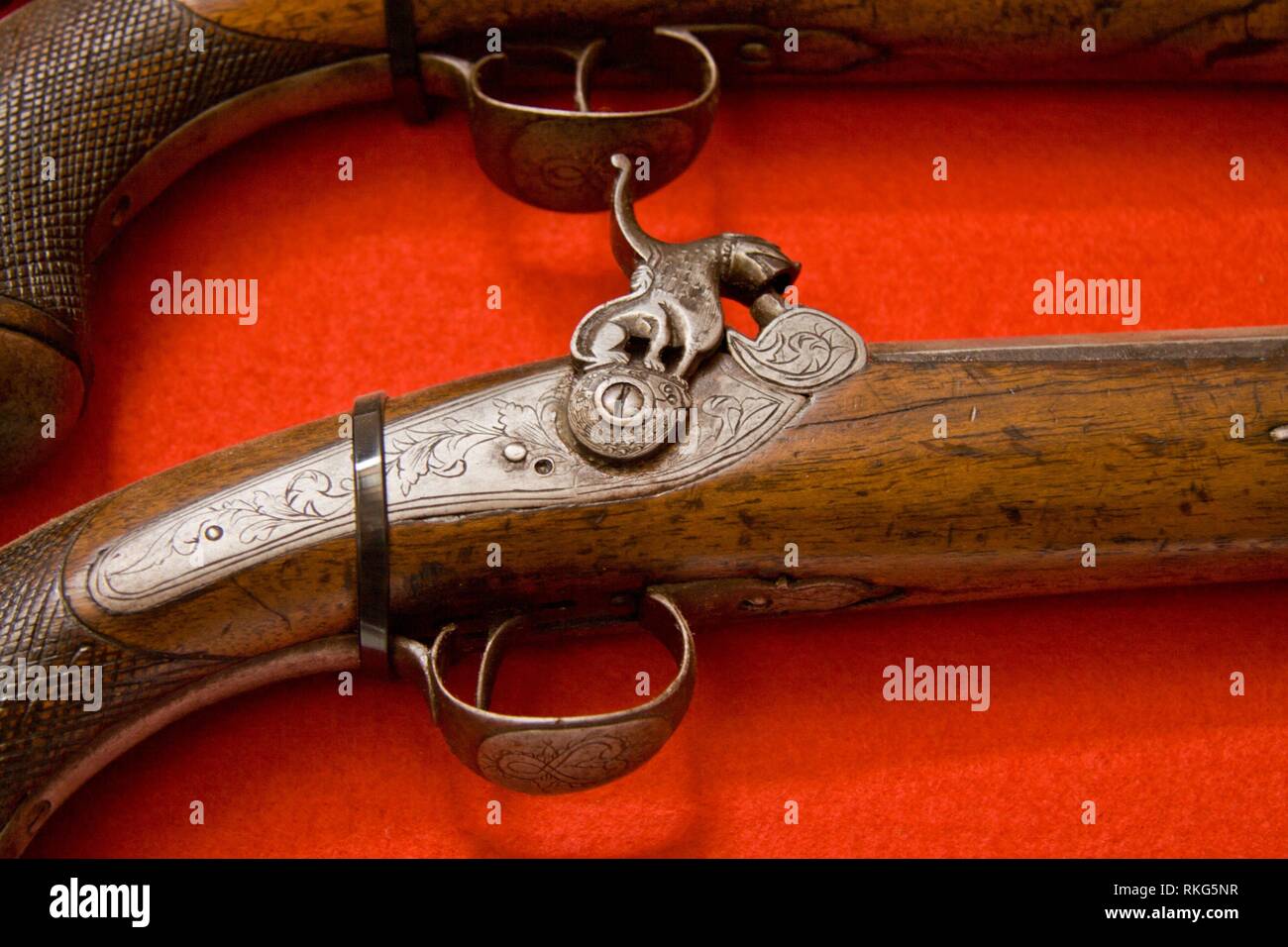 Old wooden gun isolated on red background, Caceres, Spain. Stock Photo