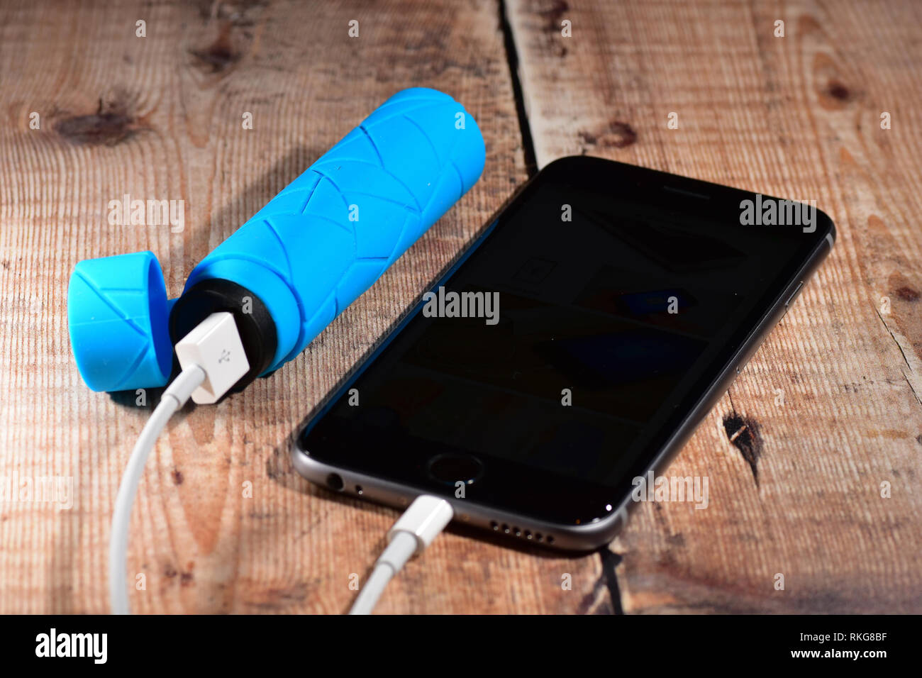 Power bank connected to a smart phone - iPhone Stock Photo