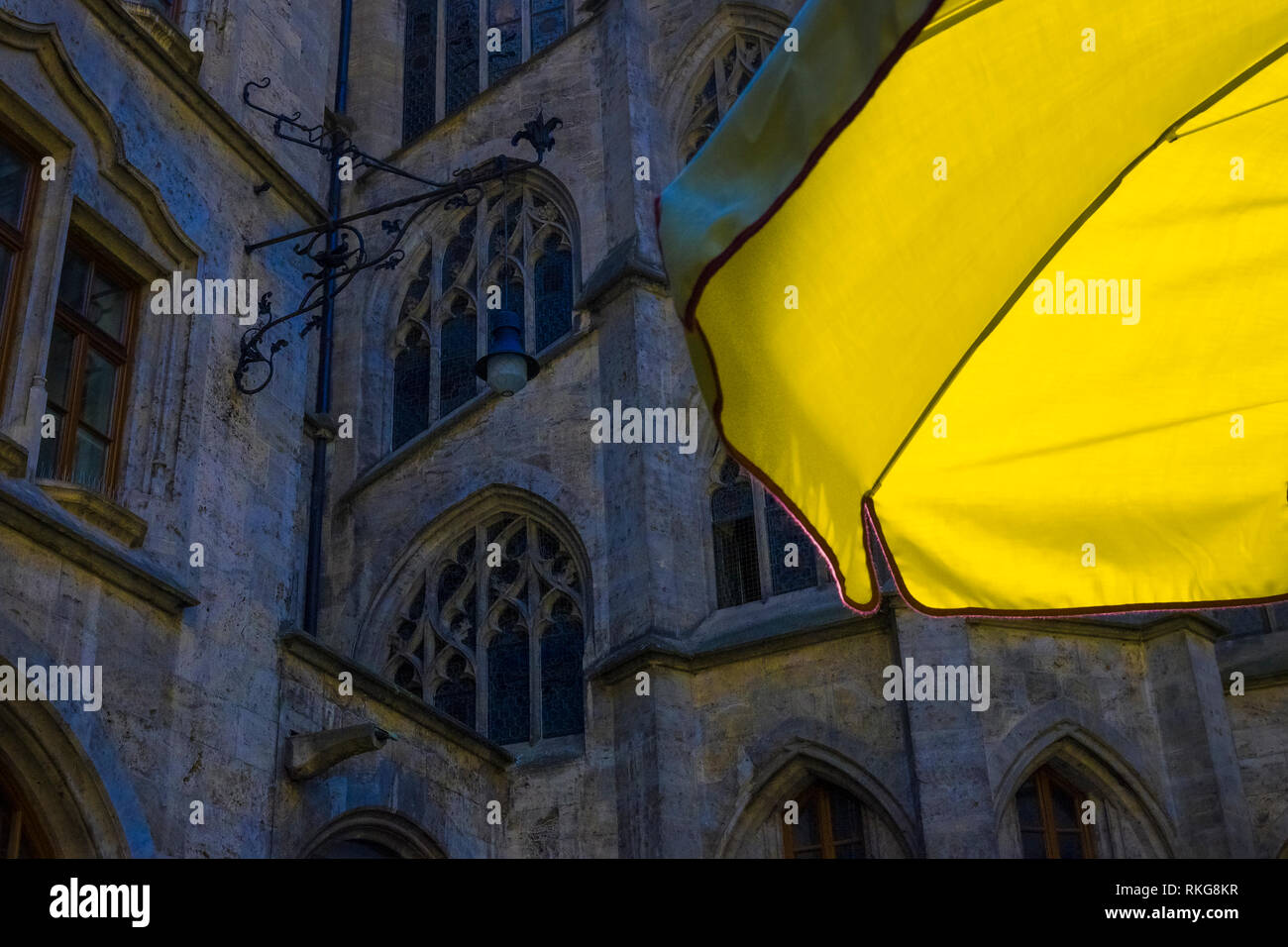 An open yellow parasol behind the Munich Town Hall Clock Tower (Rathaus