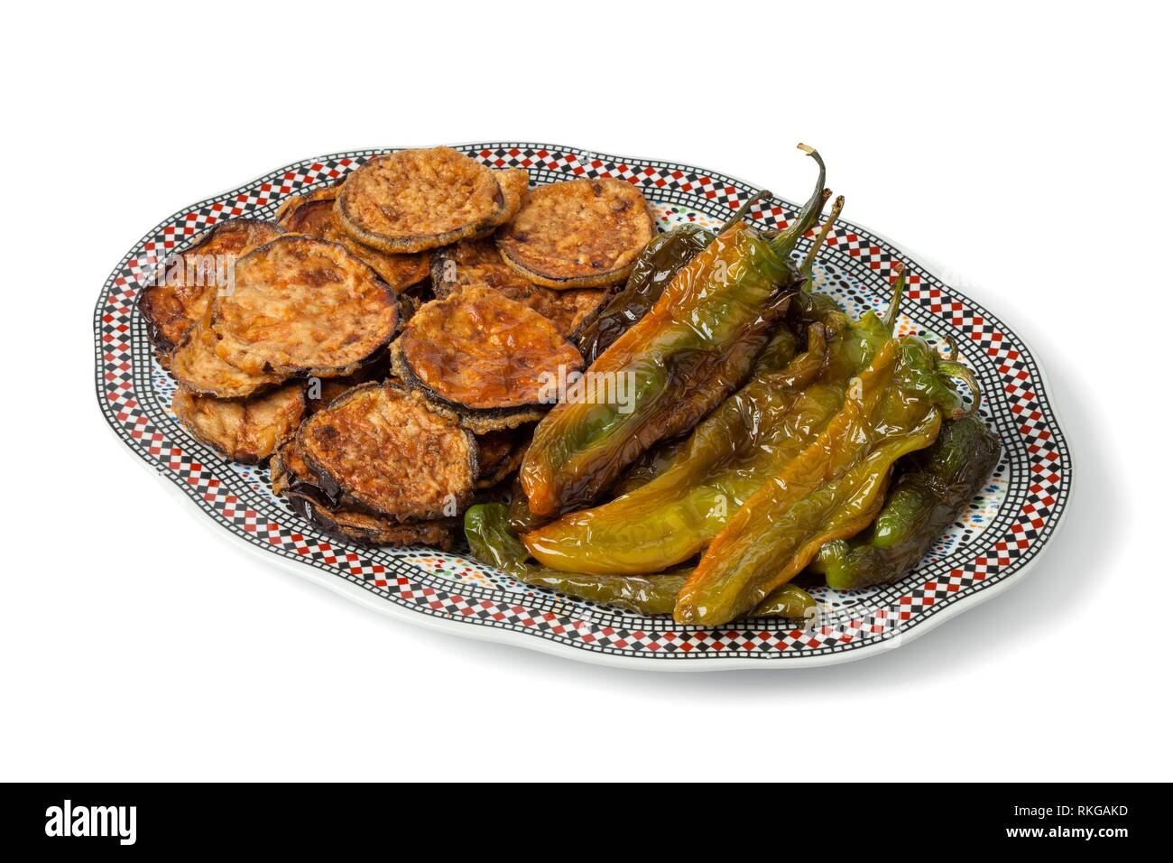 Moroccan dish with baked eggplants and green bell peppers isolated on white background. Stock Photo