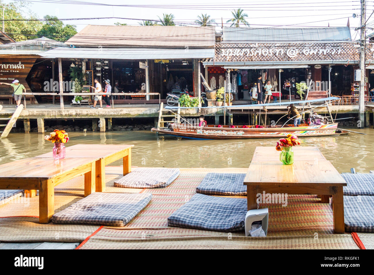 Amphawa, Thailand - 3rd March 2017: Traditional Thai seating and tables at restaurant by the river.  Weekends are busy as there is a floating market. Stock Photo