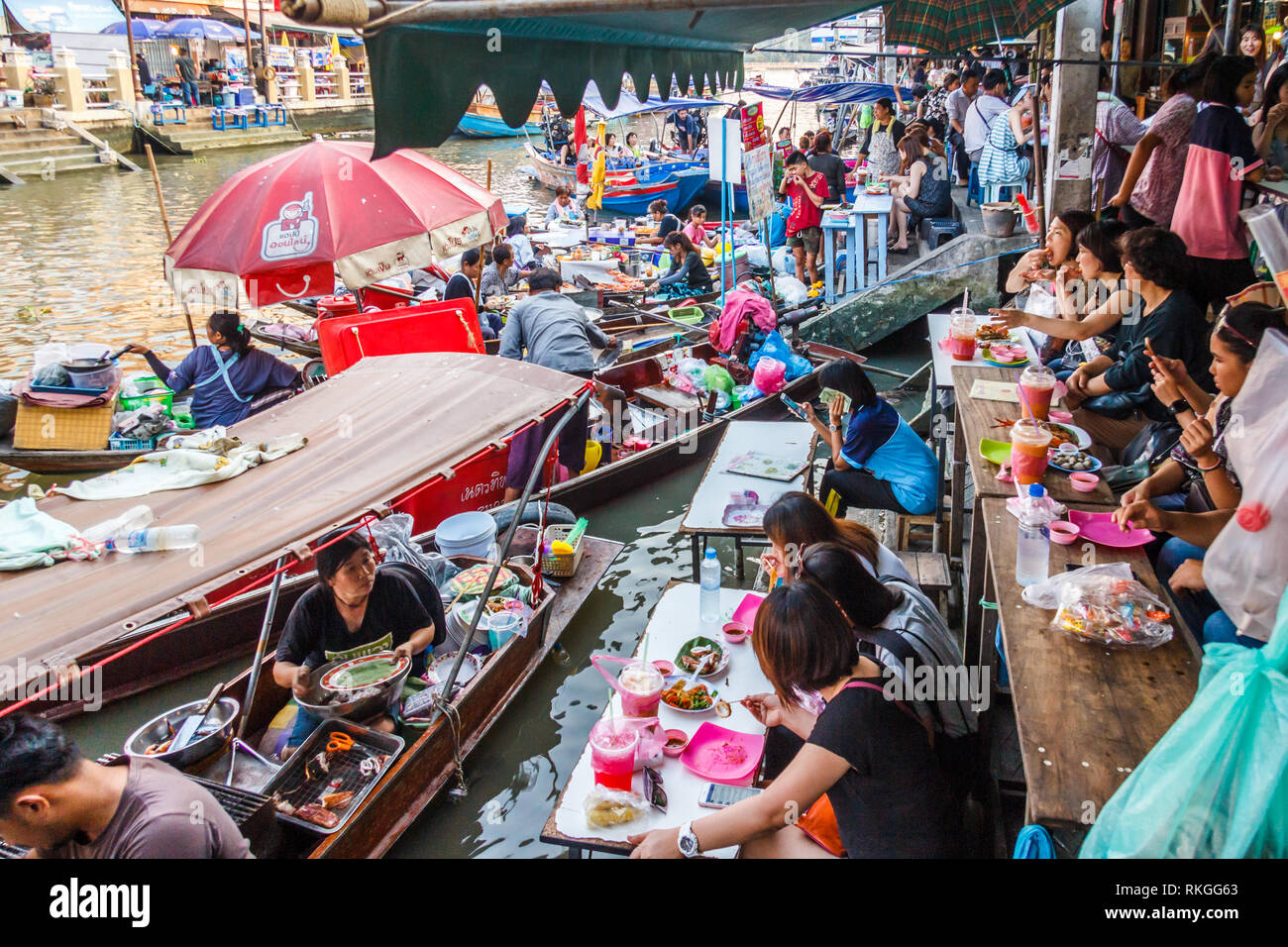 Amphawa, Thailand - 3rd March 2017: Food vendors and diners on the river. The floating market operates at weekend. Stock Photo