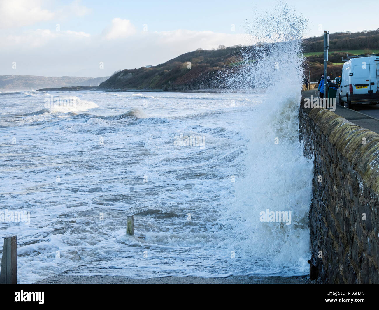 Rough sea and waves crashing against the sea wall on seafront during windy weather at high tide. Benllech, Isle of Anglesey, Wales, UK, Britain Stock Photo
