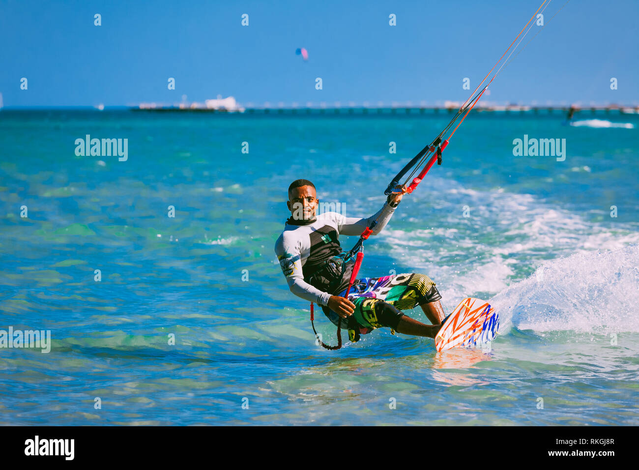 Egypt, Hurghada - 30 November, 2017: The kiter on the wakeboard holding the kite straps. The wave riding over the crystal clear Red sea surface. The p Stock Photo