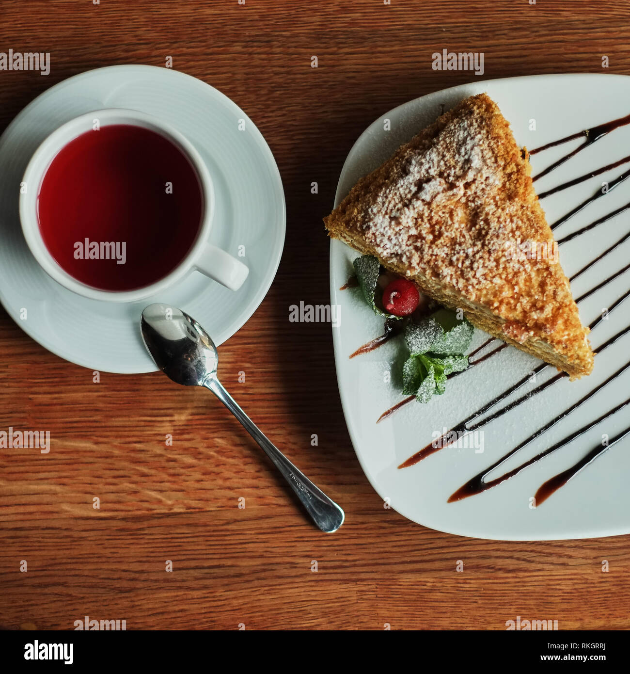 a piece of poured honey cake with chocolate topping on a plate, top view, set. Stock Photo