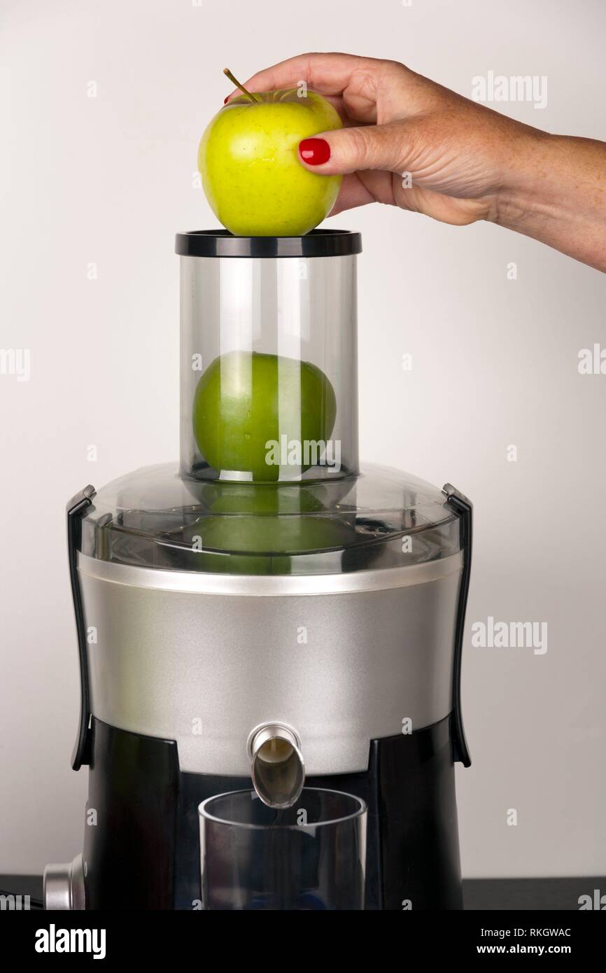 https://c8.alamy.com/comp/RKGWAC/a-womans-hand-holding-an-apple-ready-for-dropping-into-a-juicer-prior-to-making-a-fruit-and-vegetable-smoothie-RKGWAC.jpg