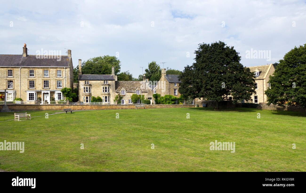 Cotswold homes alongside the green in Shipton-under-Wychwood, Oxfordshire, UK. Stock Photo