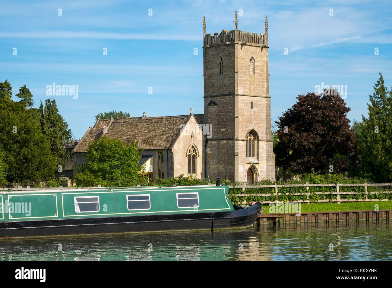 Late spring sunshine on colourful narrowboats moored near St Marys Church on the Gloucester & Sharpness Canal at Frampton on Severn, Gloucestershire, Stock Photo