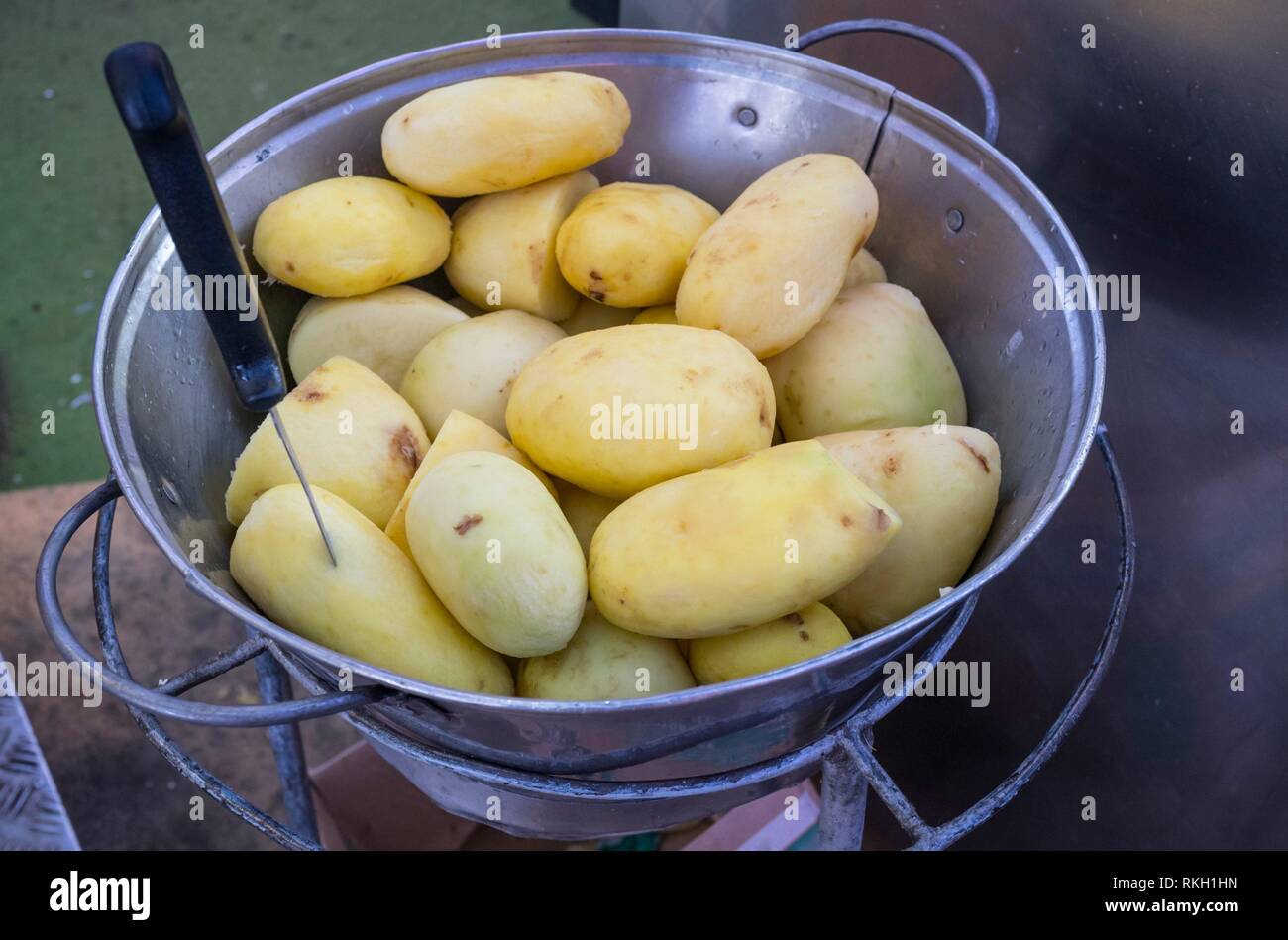 Peeled potatoes ready to be fried at fairground stall. Closeup. Stock Photo