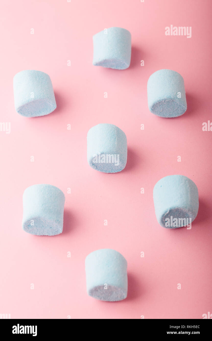 Pattern of blue marshmallows on plain pink background Stock Photo