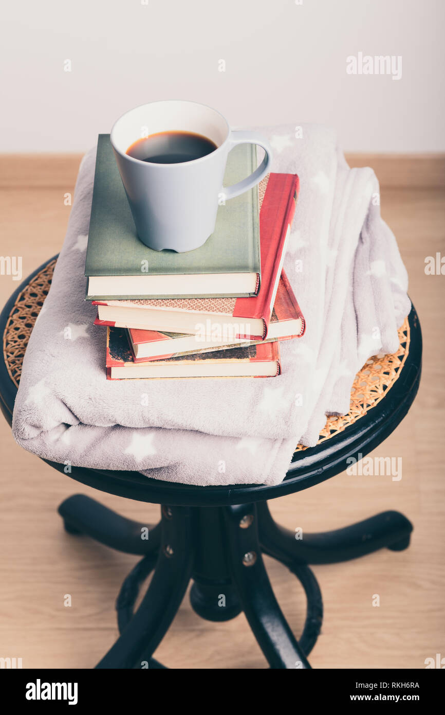 A Few Books With Cup Of Coffee And Blanket On Wooden Chair