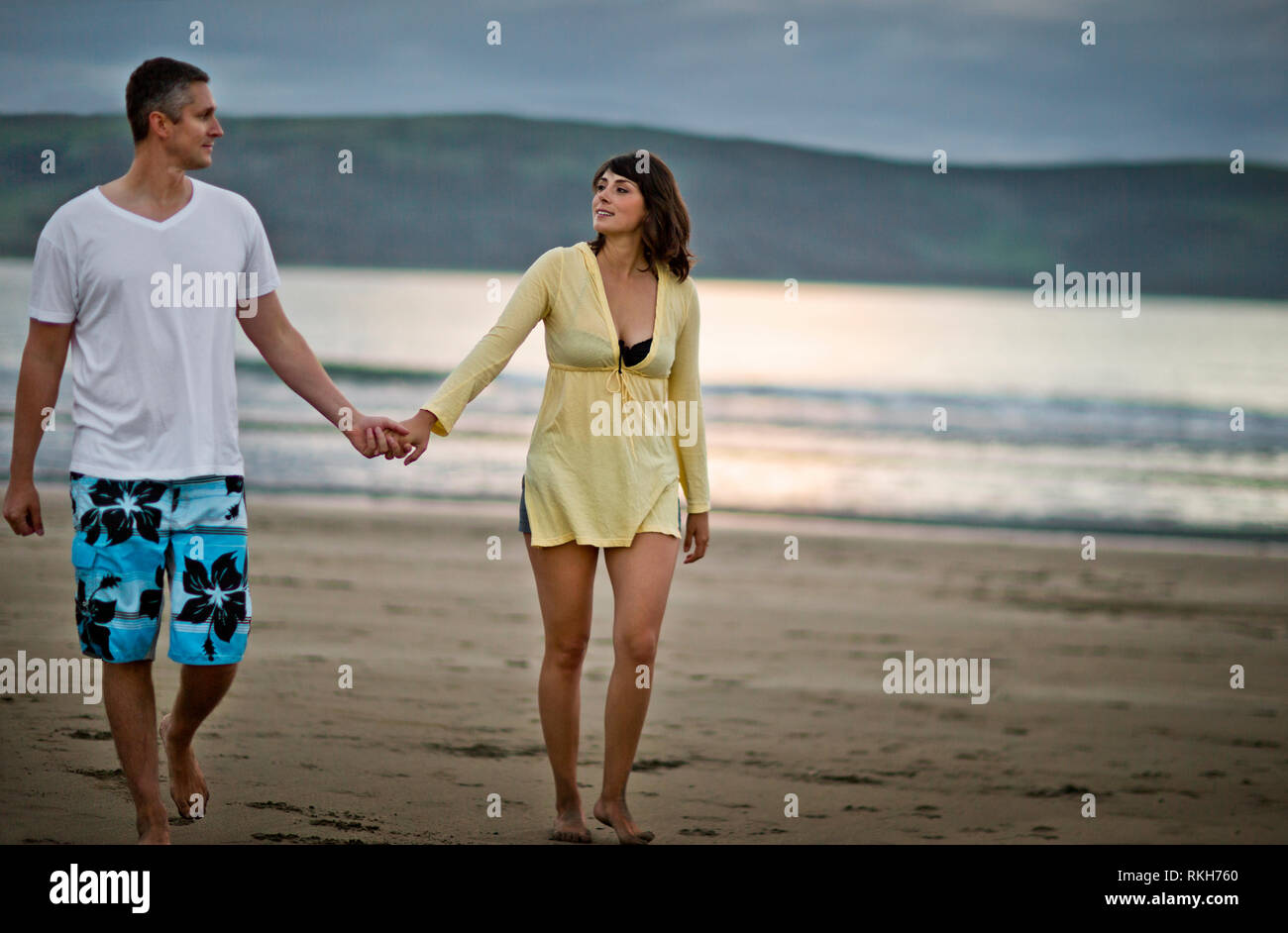 Middle aged couple walking hand in hand on the beach Stock Photo - Alamy