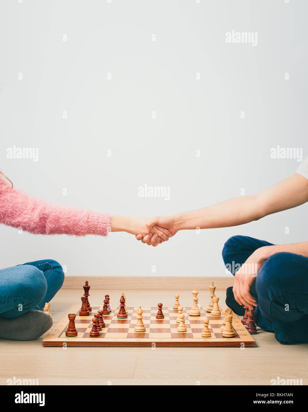 Chess game is over. Girl and boy handshaking after finished chess game, thanking for playing. Copy space for text at the top of image Stock Photo