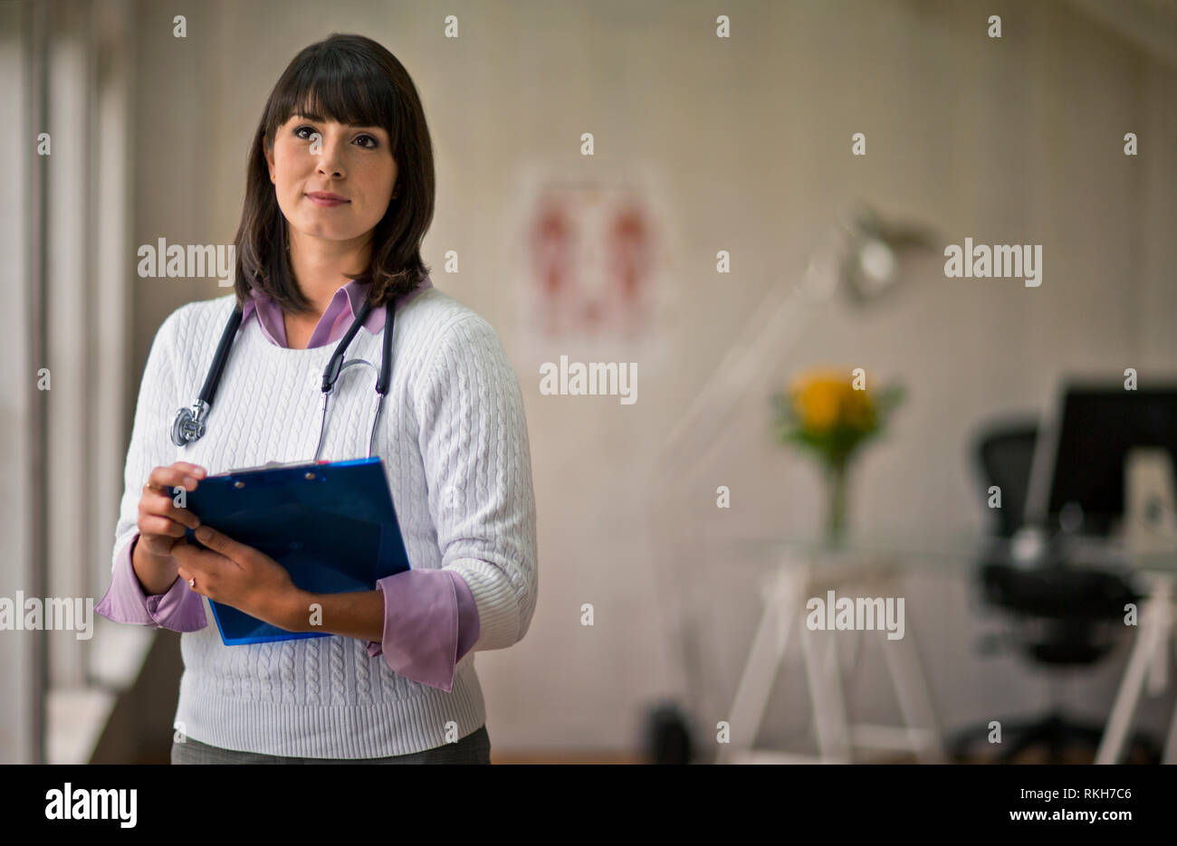 Portrait of a young female doctor holding a clipboard in her office. Stock Photo