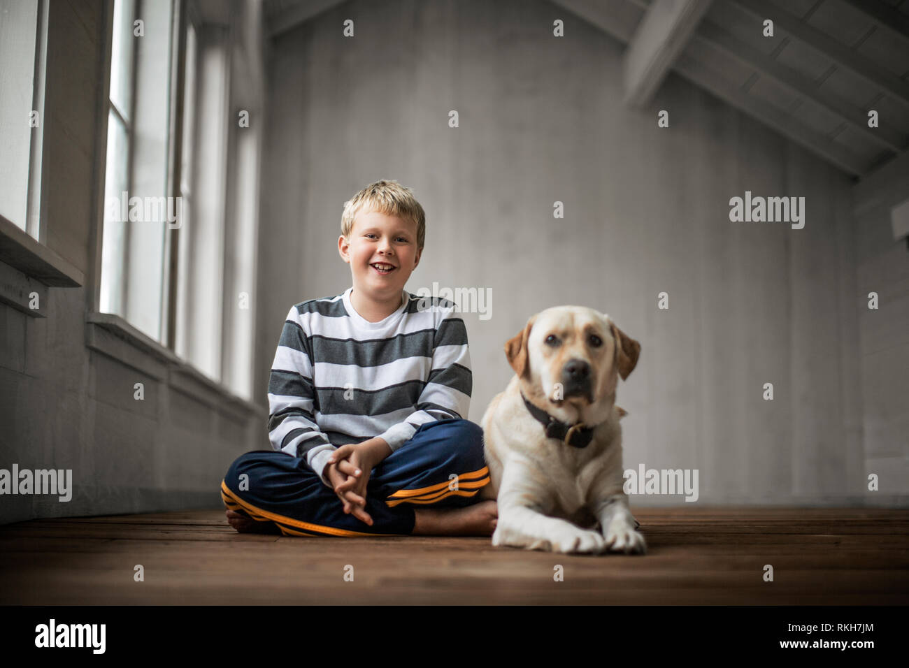 Happy young boy sitting with his dog Stock Photo - Alamy