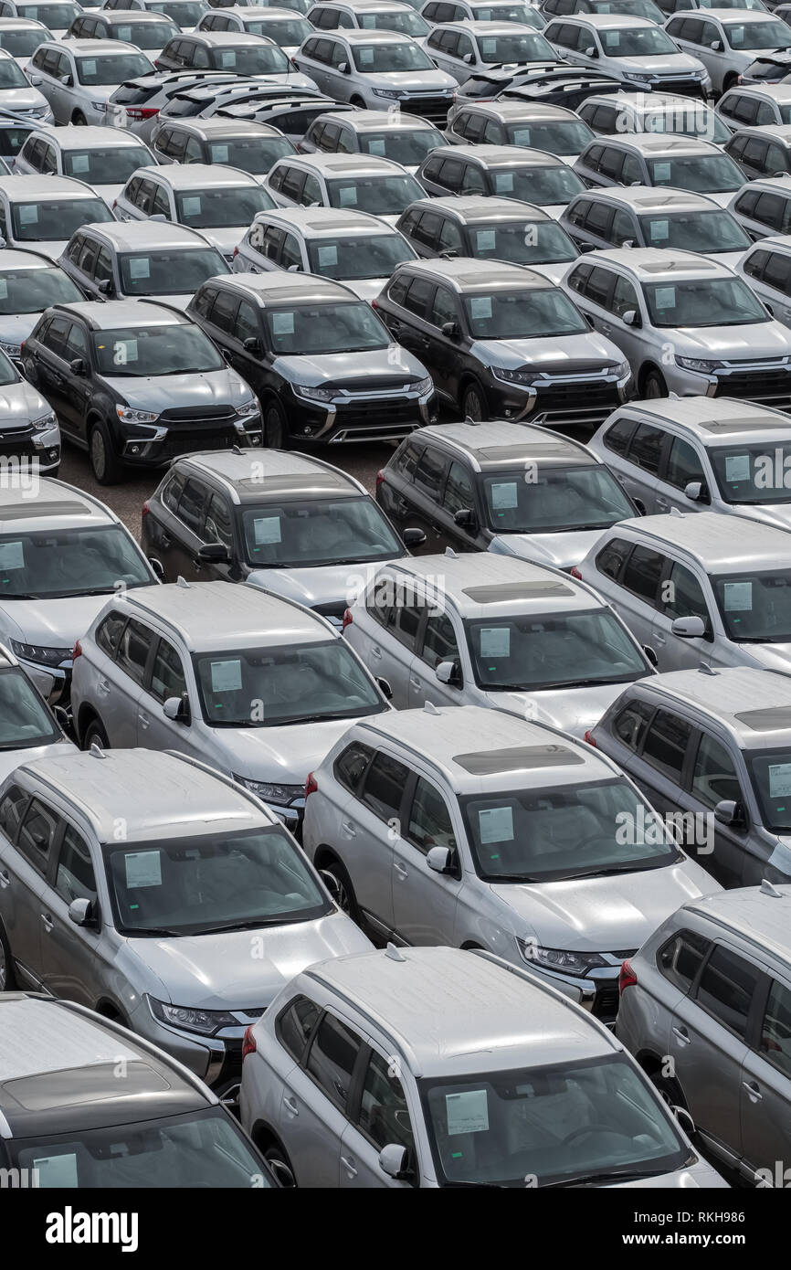 Row of new cars for sale in port. New automobiles background Stock Photo