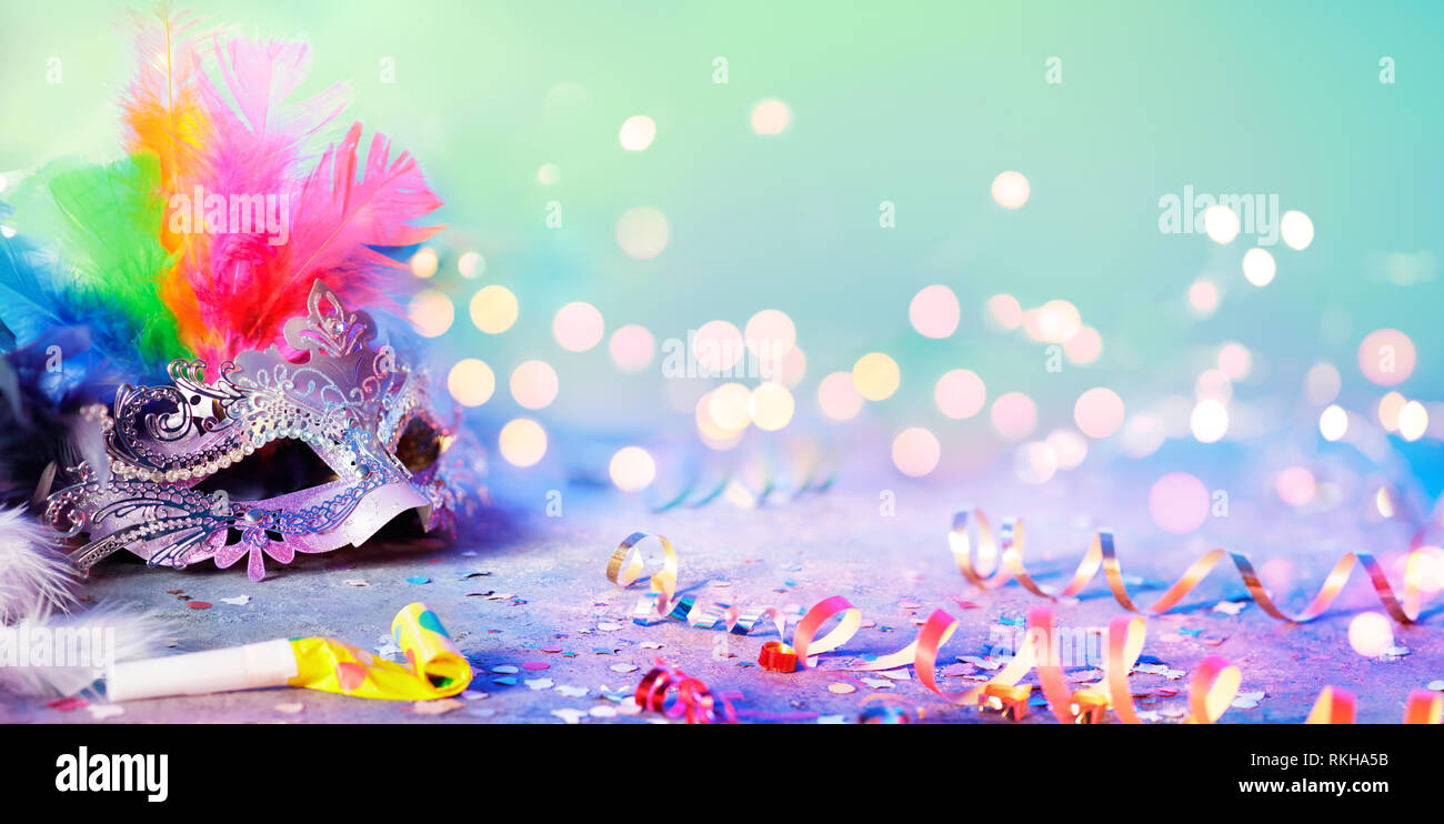 Carnival Mask With Blurred Streamer, Party Confetti And Bokeh Stock Photo
