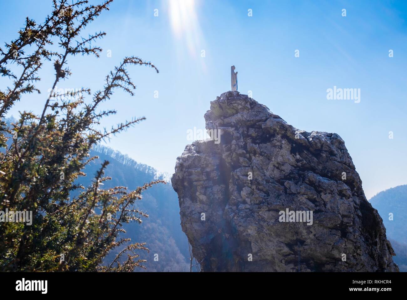 Italy, Lombardy, Varese, statue of the most holy Virgin Mary over a rock, bathed in rays of sun from the sky. Stock Photo