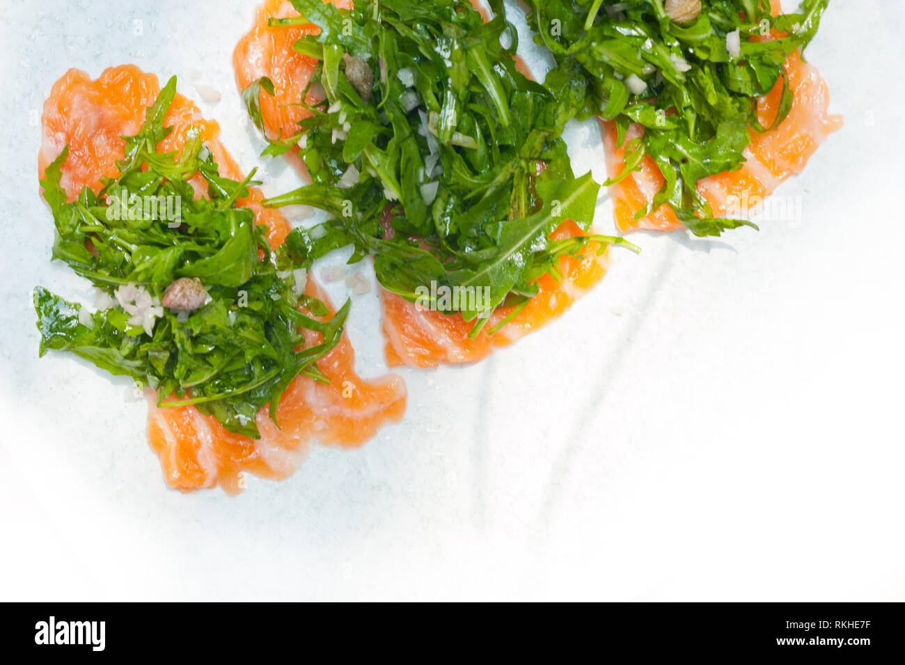 fresh salmon carpaccio sushi sashimi with arugula rocket salad and