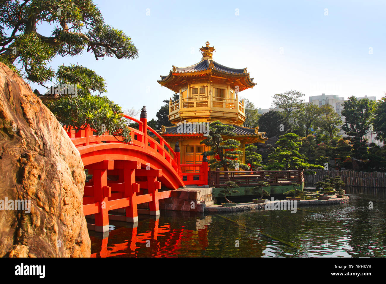 The Golden pavilion and red bridge at sunrise, in Nan Lian Garden near Chi Lin Nunnery, famous landmarks in Hong Kong . Stock Photo