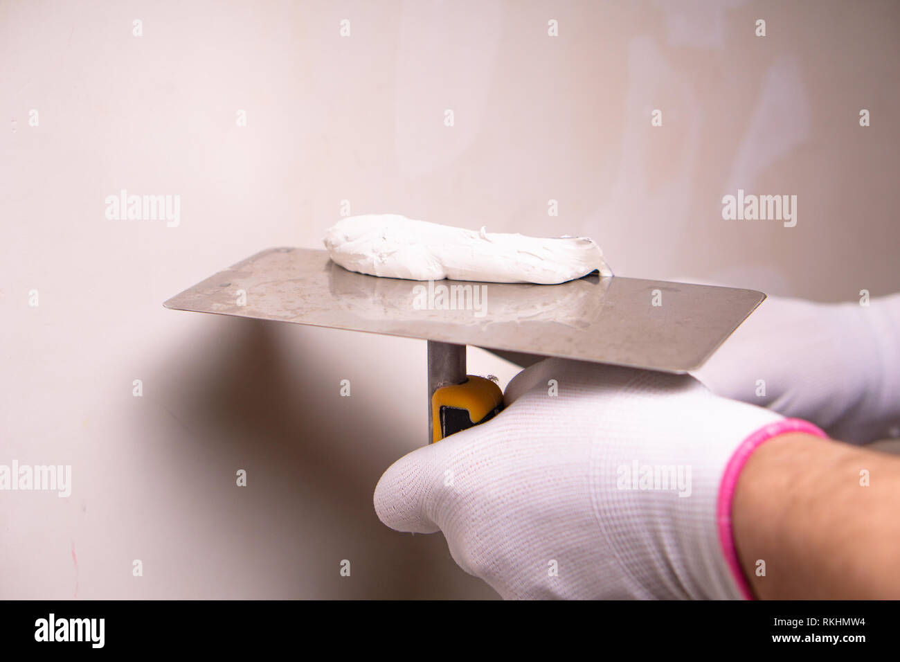 Hand with putty knife repair wall, Hand with a spatula, spatula with