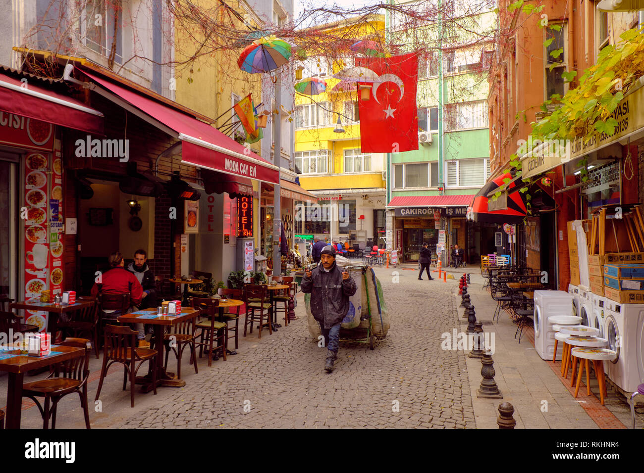 Local man recuperating goods  on a Pedestrian street lined with business in the core of Kadikoy, on the asian side of Istanbul, Turkey - December 2018 Stock Photo