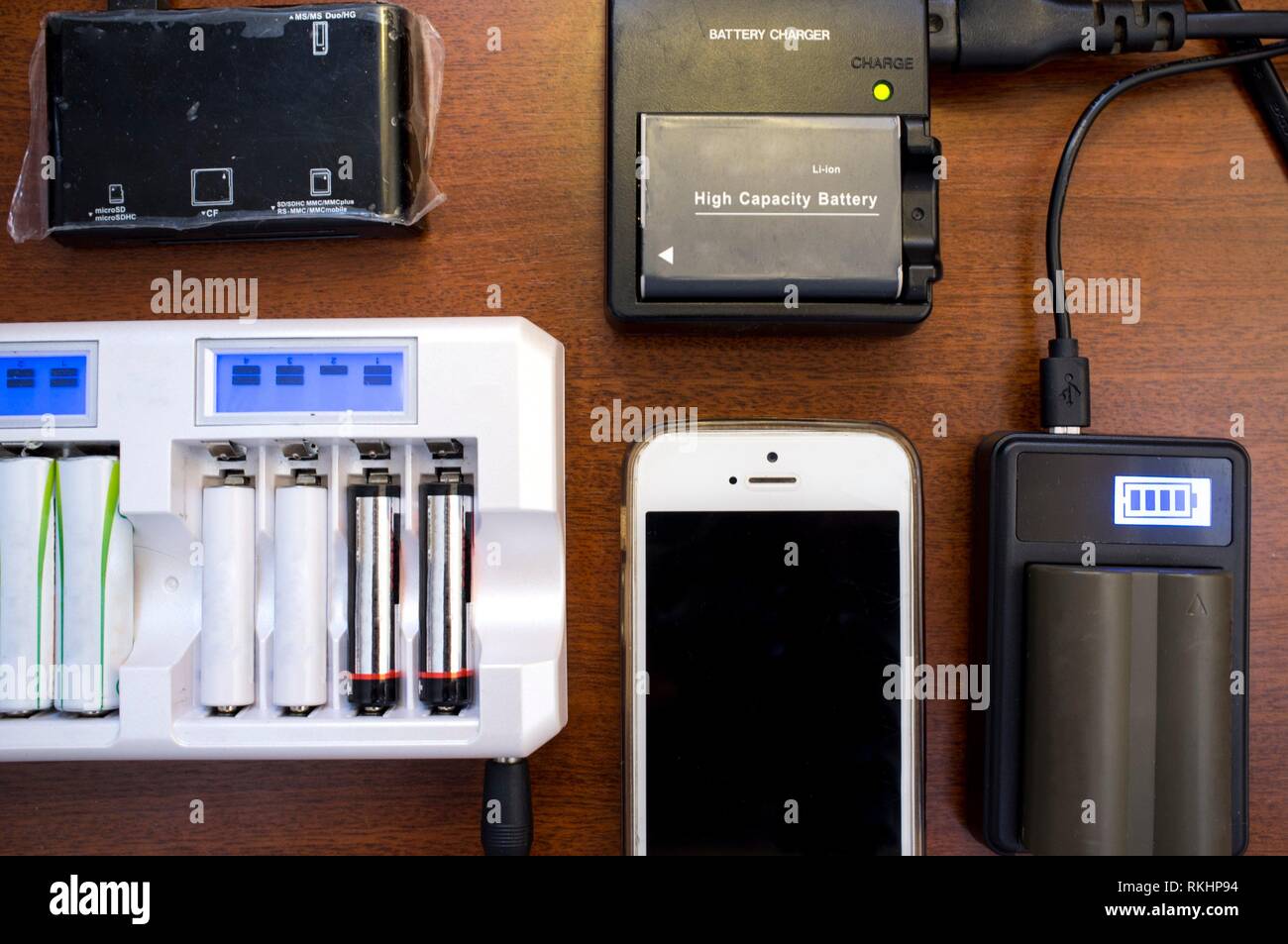 Lots of charger devices as mobile, rechargable batteries, camera batteries, etc. Overhead shot. Stock Photo
