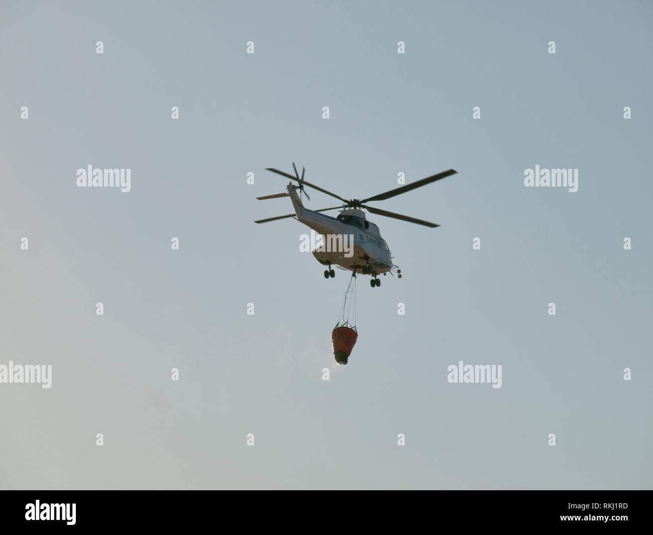 Fire fighting helicopter carrying water bag to drop in fire Stock Photo Alamy