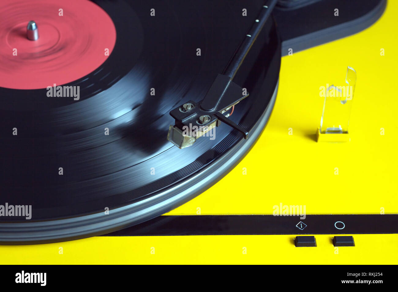 Turntable in yellow case playing a vinyl record with red label ...