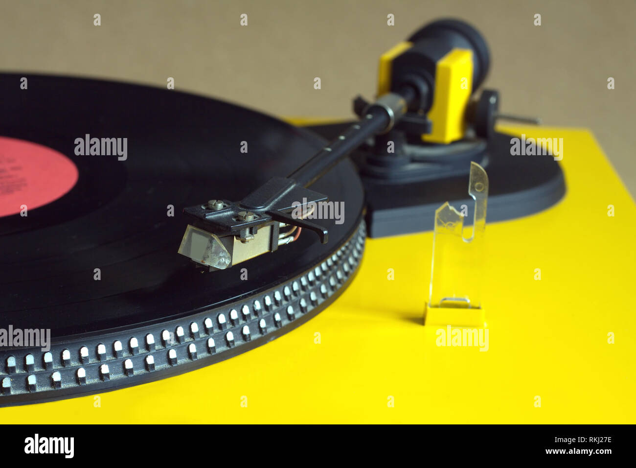 Turntable in yellow case playing a vinyl record with red label ...