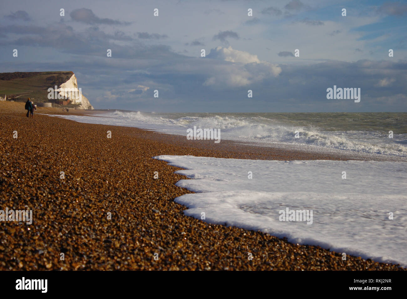 South England, Seaford stony beach. Wild sea. White cliffs (Seven sisters) in the background. Stock Photo