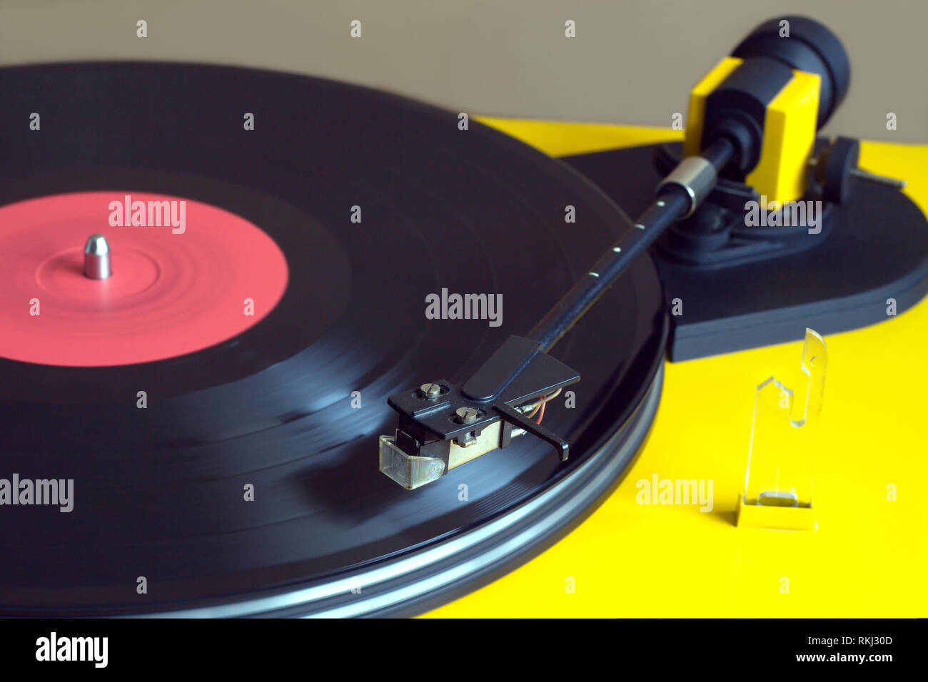 Turntable in yellow case playing a vinyl record with red label ...