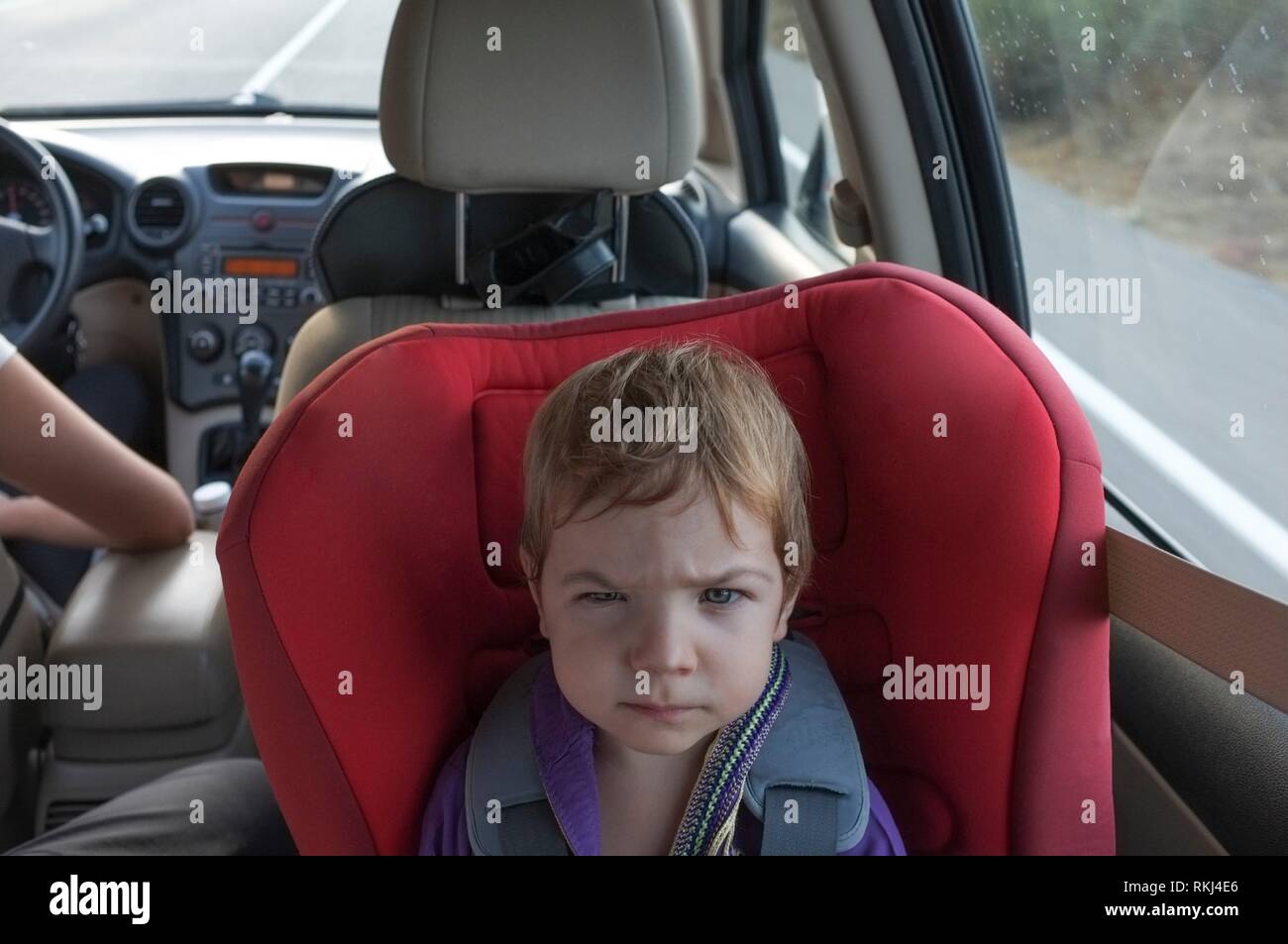 Petit bébé dans un siège de voiture dans la voiture. Tirer tout droit.  L'enfant regarde la caméra Photo Stock - Alamy