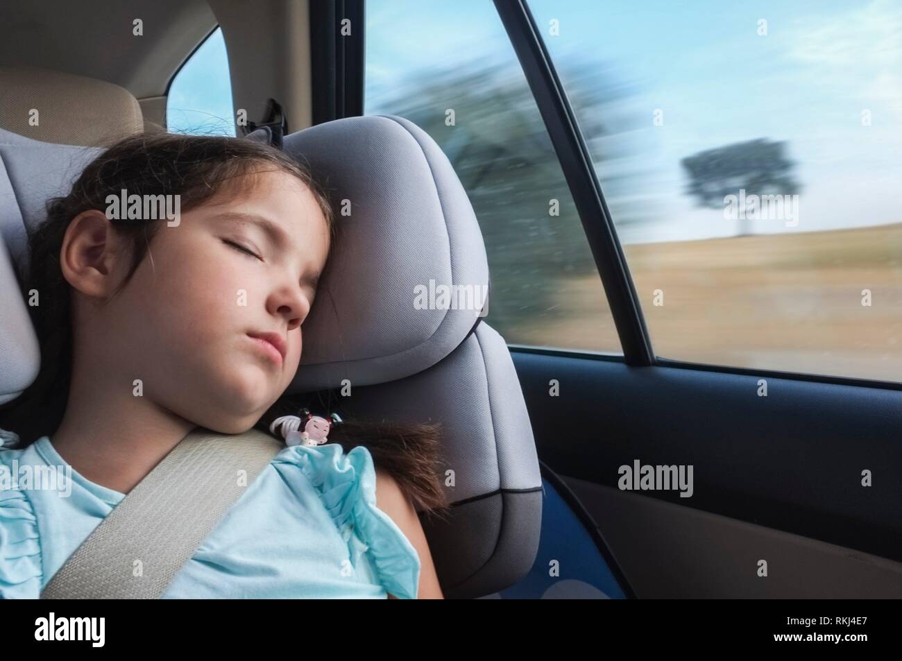 Child girl asleep in a child safety seat in a car. Natural light Stock