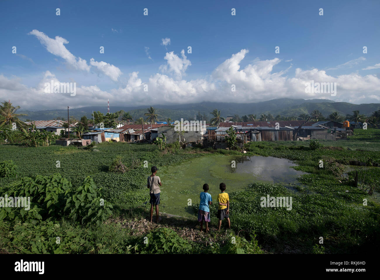 Township, Kids at pond near shacks, Dili, East Timor Stock Photo
