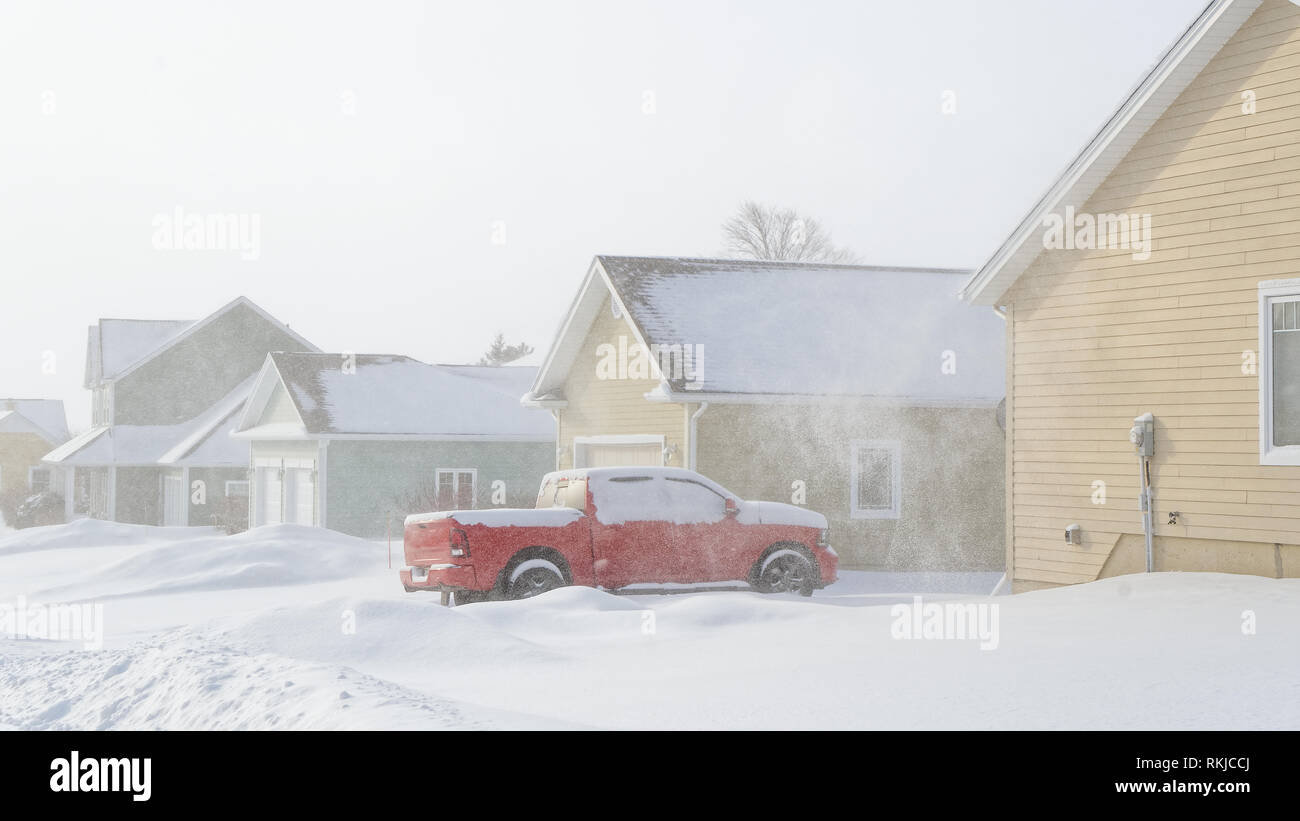 Truck parked in the driveway during a snow storm in a North America neighborhood. Stock Photo