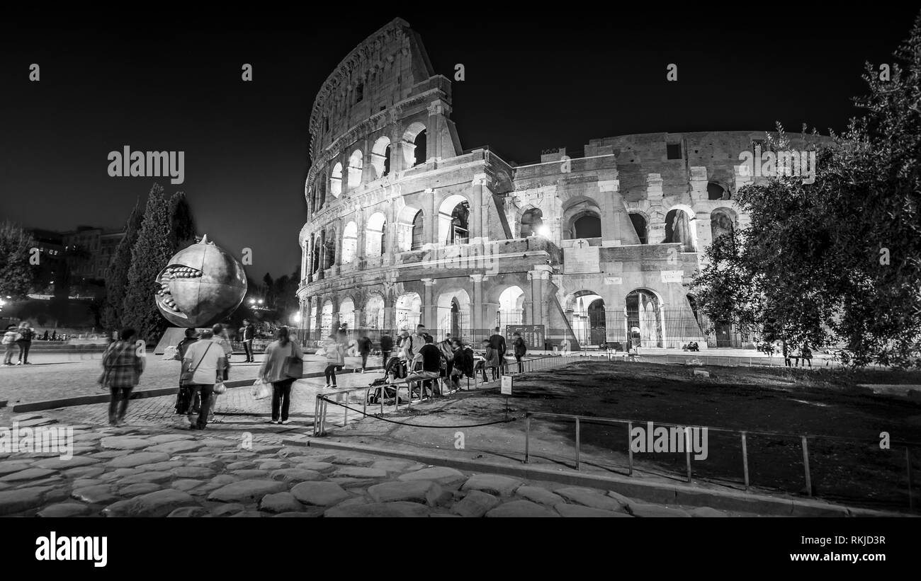 Roman Colosseum and Tourists at Night in Rome, Italy, people blurred Stock Photo