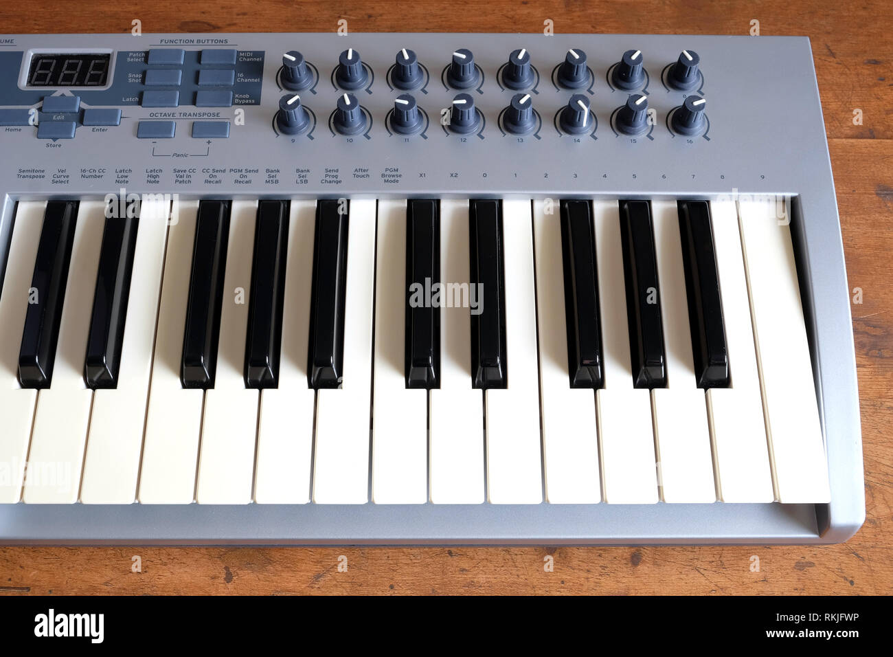 Electronic synthesizer keyboards with many control knobs in silver