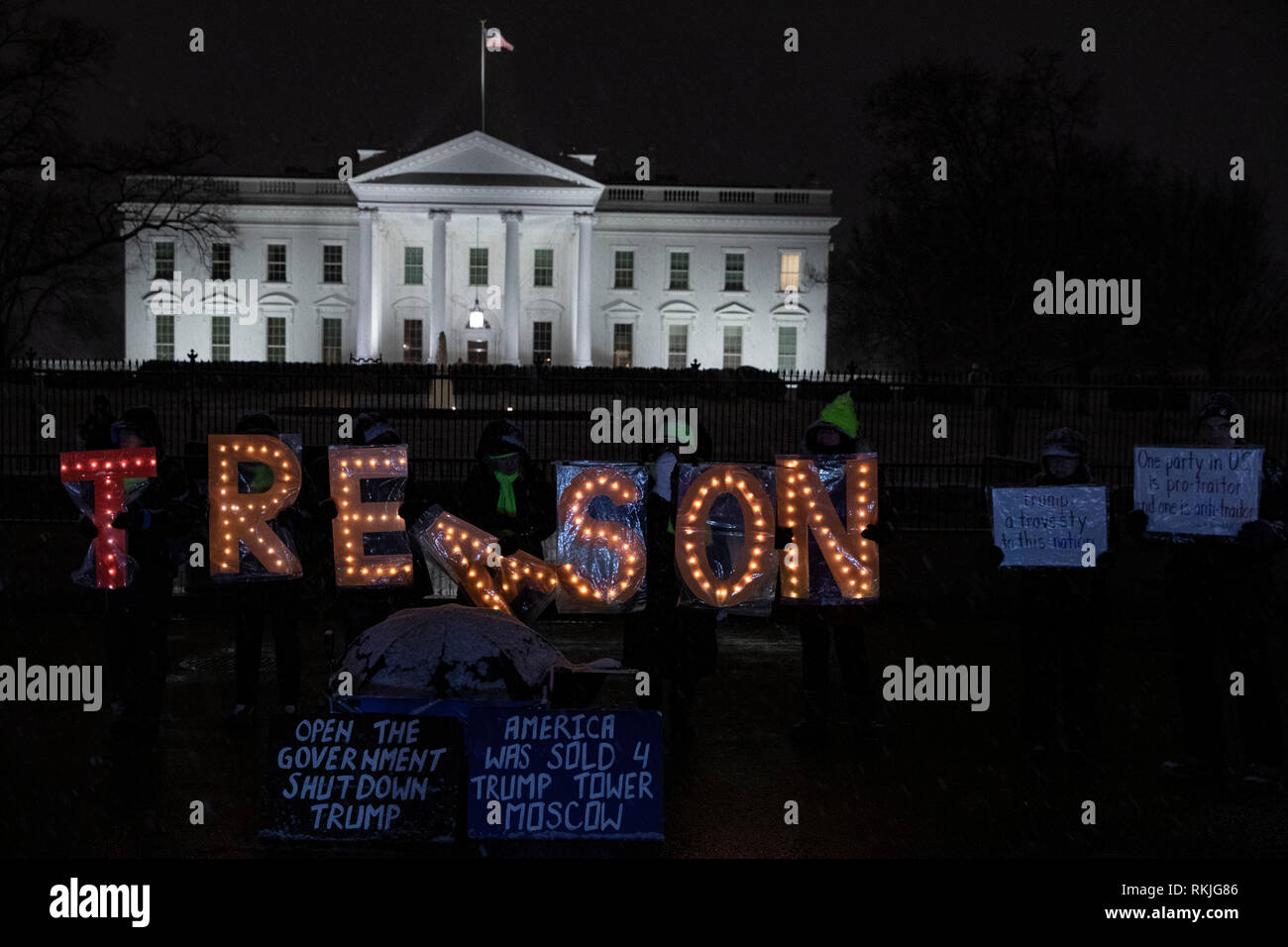 Demonstrators hold illuminated letter signs that read 'Treason' while protesting outside of the White House during the partial government shutdown in Washington, D.C., U.S, on Saturday, Jan. 12, 2019. Stock Photo